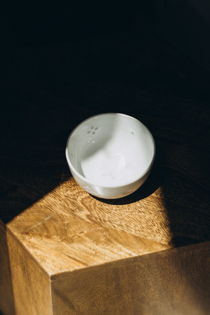 Dayflower porcelain teacup beside flowers in natural light.