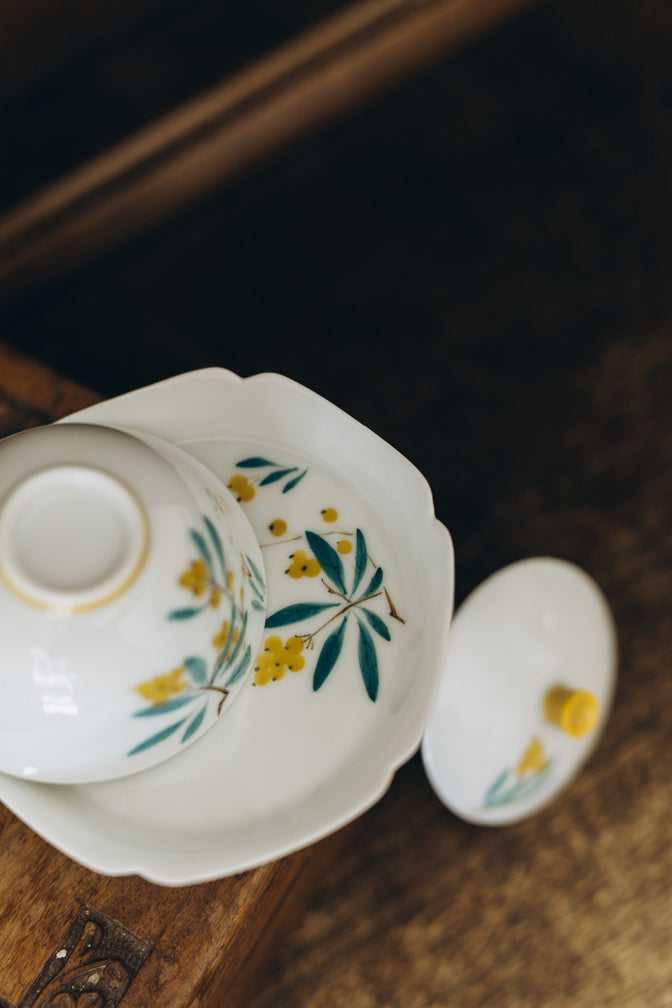 Japanese Plums gaiwan turned over beside its lid to show the floral decoration and base.