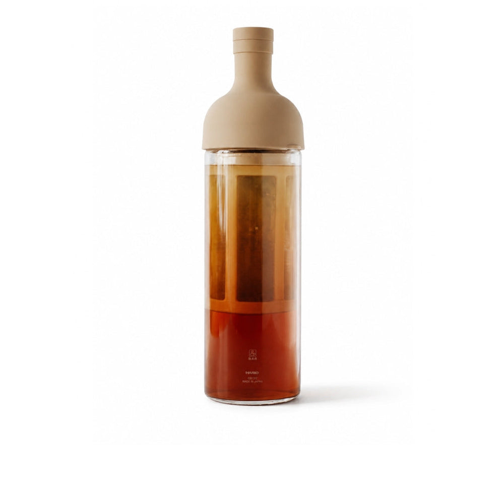 Tall cold brew tea bottle filled with tea, with a tan bottle-shaped cap.
