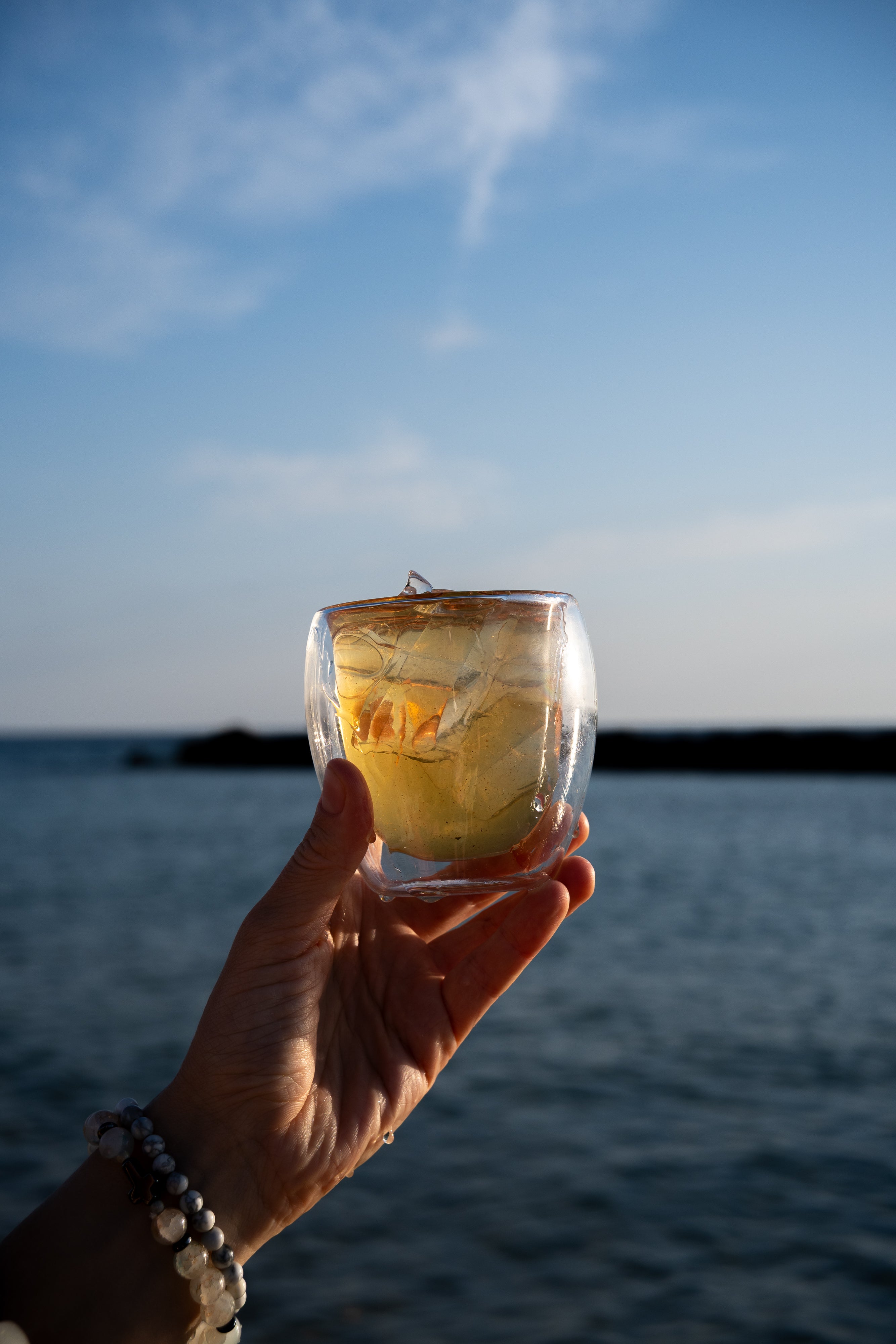 A glass of tea beside the evening sea